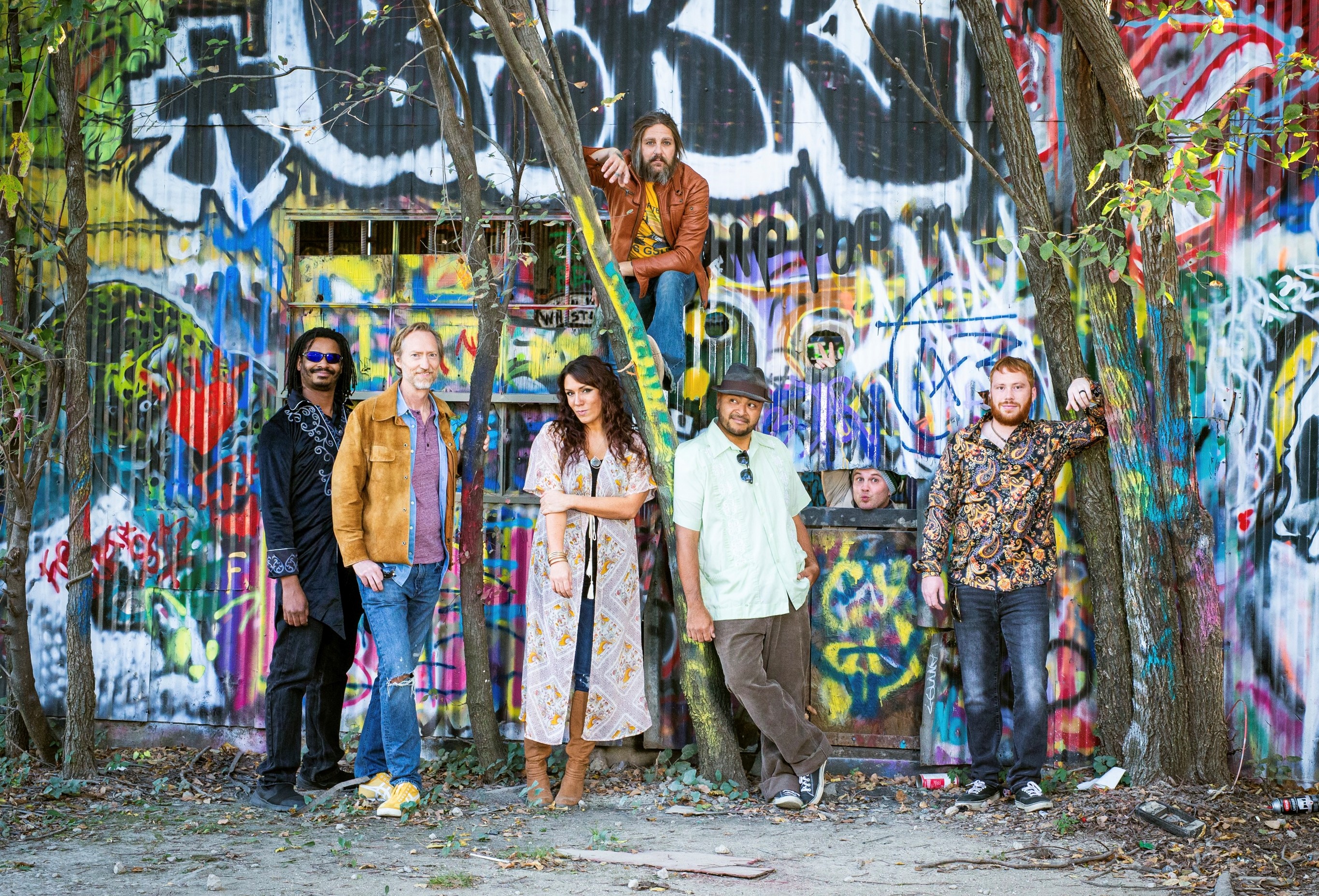 Band posing by outdoor graffiti