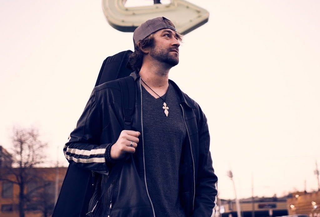 Jimmy Anderson holding guitar case