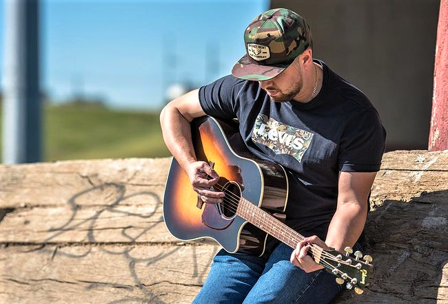 Alex Aguilar playing guitar outside