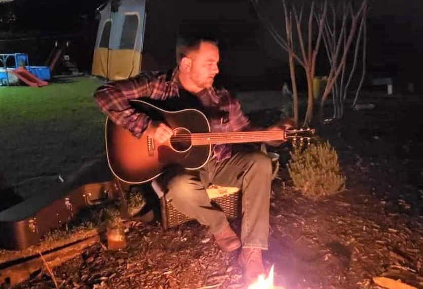 Guitarist by campfire